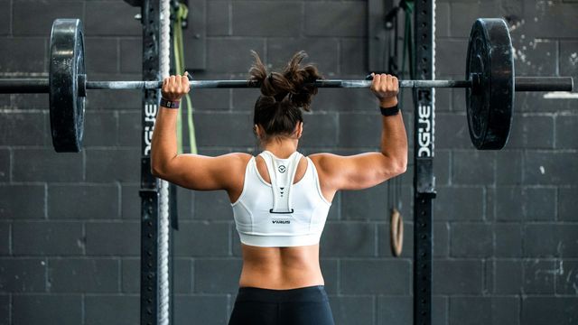 A woman holding a barbell above her head. 